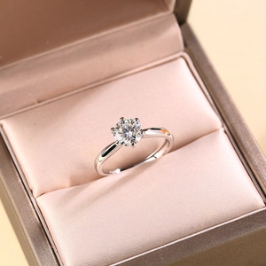 Detailed view of a six-prong crown solitaire ring with a round diamond in a gift box