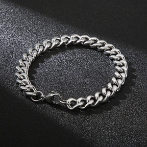 Close-up of a polished silver Cuban link chain bracelet with a secure lobster clasp
