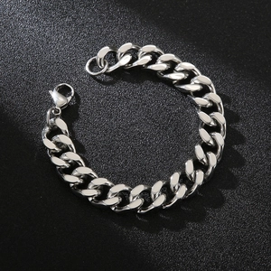 Close-up of silver Cuban link bracelet with lobster clasp on a black textured background