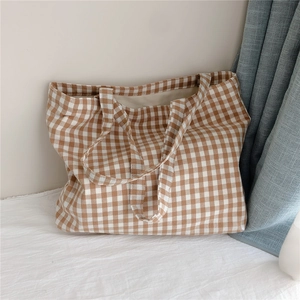 Close-up of brown and white checkered cotton tote bag texture and soft woven handles