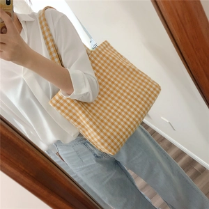 Detailed close-up of yellow and white gingham canvas tote bag with wide shoulder straps