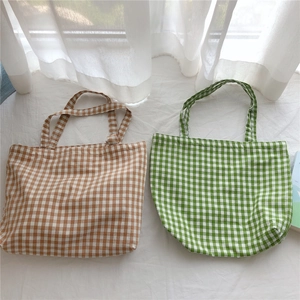 Flat lay of checkered cotton tote bags in brown and green with soft fabric texture