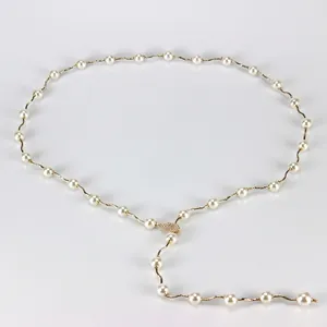 Elegant gold wavy chain necklace featuring white pearls and a sparkling diamond leaf pendant