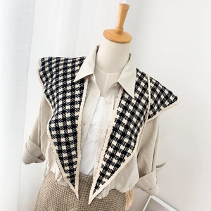 Knitted houndstooth shawl wrap accessory shown on a mannequin with classic black and white pattern