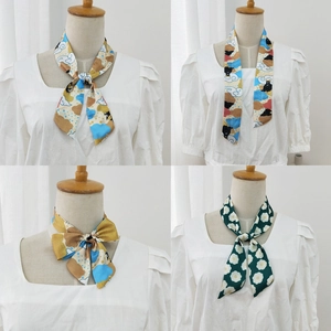 Detail of printed silk scarves showing cartoon bear and floral patterns tied on a neck