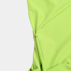 Detailed view of bright green woven fabric with side tie knot and elegant ruching