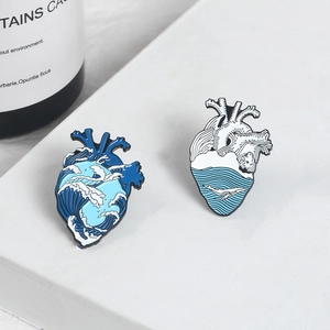 Detailed view of creative enamel heart pins featuring ocean waves and whale designs