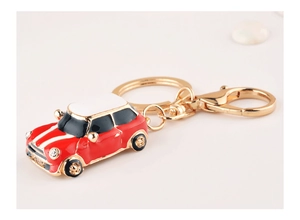 Detail of red beetle car keychain with white stripes and metal lobster clasp