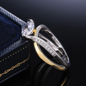 Élégant ensemble de bagues bicolores avec zircon ovale sur une boîte en velours bleu