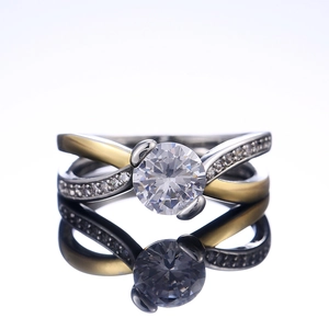 Détail d'une bague de fiançailles bicolore avec zircone ronde et accents pavés
