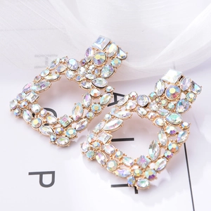 Detail of square gold earrings with multi-shaped iridescent AB crystals and rhinestones