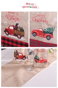 Detail of Christmas linen table runner with red truck embroidery and buffalo plaid edges