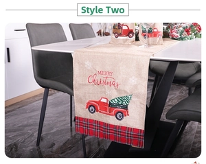 Detail of Christmas table runner with red truck print and green plaid border decor