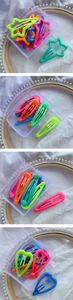 Close-up of candy colored metal hair clips in star, heart, and teardrop shapes