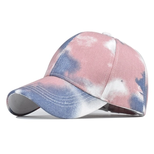 Detailed close-up of pink and blue tie-dye cotton fabric on a baseball cap brim