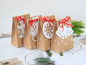 Dettaglio di sacchetti regalo di Natale in carta kraft con fiocchi e cartellini