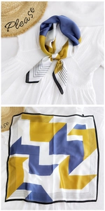 Detail of silk-like neck scarf with yellow and blue geometric patterns in a knotted style