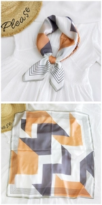 Detail of silk-feel geometric square scarf with orange and grey patchwork design