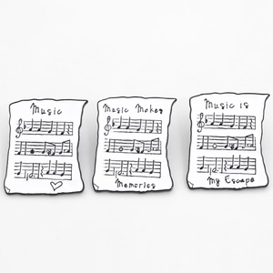 Lot de trois broches en émail dessin animé avec partitions et citations musicales en noir