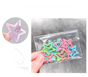 Detailed view of colorful star shaped metal snap hair clips in macaron pastel tones