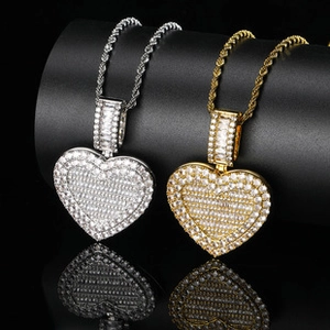Close-up of hip hop rotating heart pendants in gold and silver with sparkling crystals