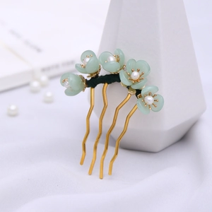 Detailed close-up of handmade Hanfu hair comb with green flowers and pearls