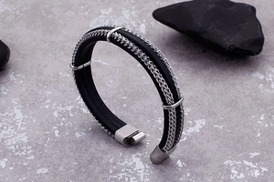 Macro view of men's braided leather bracelet with stainless steel chain and buckle