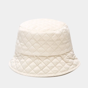 Macro detail of beige quilted diamond pattern on a warm winter bucket hat for women