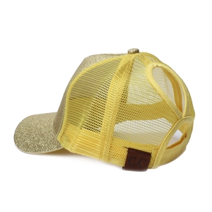 Detail view of the criss-cross ponytail opening on gold sequin baseball mesh cap