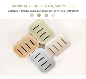 Vue de dessus de quatre boîtes à savon minimalistes colorées avec fentes de drainage et bords