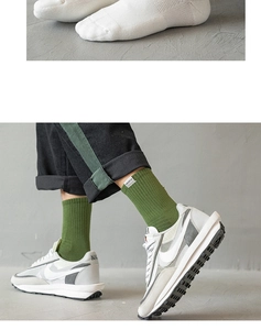 Detail of white and green crew socks featuring a cushioned towel sole and fabric label
