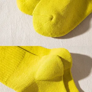 Detailed view of reinforced toe and 3D heel construction on yellow cotton sport socks
