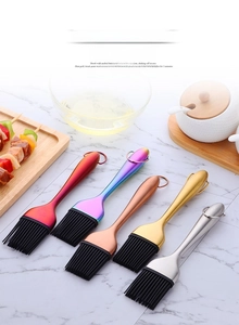 Dettaglio di pennelli in silicone colorati con manici in acciaio inox su tavolo di marmo