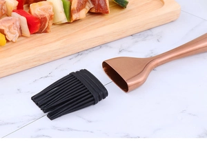 Dettaglio macro del pennello in silicone con manico rimovibile in acciaio oro rosa