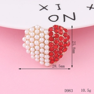 Detail shot of heart-shaped alloy charm with white pearls and red rhinestones 28mm