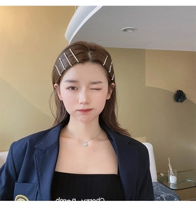 Détail de barrettes en strass étincelants et collier trèfle argenté sur un mannequin