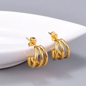 Elegant 18K gold plated titanium steel triple-line hoop earrings on white ceramic
