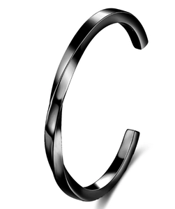Detail of black stainless steel twisted cuff bracelet with brushed metallic finish
