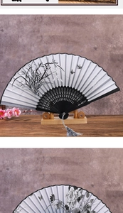 Detail view of ink bamboo and peony silk folding fans with black hollow-carved ribs