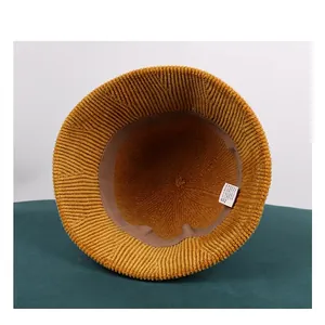 Inside view of a yellow chenille knit bucket hat with a label and inner sweatband