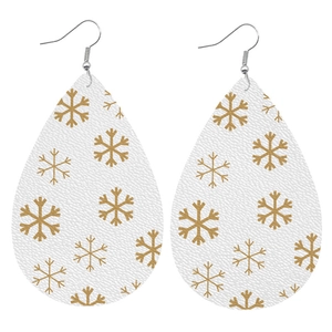 Detail of teardrop faux leather earrings featuring golden snowflake patterns on white