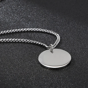 Collana minimalista in acciaio inossidabile argento con ciondolo tondo su sfondo nero