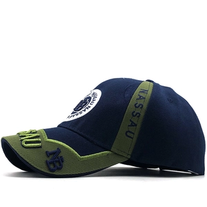 Detail of embroidered NASSAU lettering on navy and olive green baseball cap
