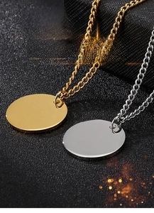 Pendenti a disco lucidati in oro e argento su catene sottili con sfondo scuro elegante