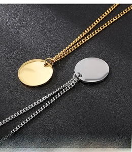 Dettaglio macro di ciondoli circolari lucidi in oro e argento su catene sottili a O