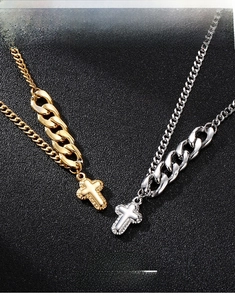 Detail of silver and gold stainless steel cross pendants on cuban link chains