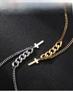 Detail of cross pendant and Cuban link chain in polished gold and silver finish