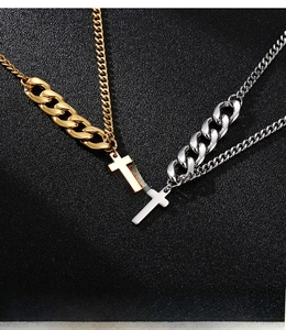 Detail of mixed-metal gold and silver cuban link chain necklaces with cross pendants
