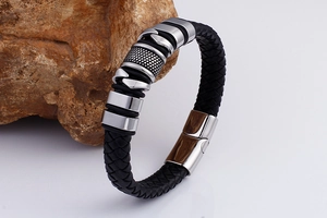 Macro detail of men's black braided leather bracelet with stainless steel magnetic clasp