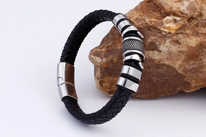 Detail of black braided leather men's bracelet with textured silver stainless steel clasp